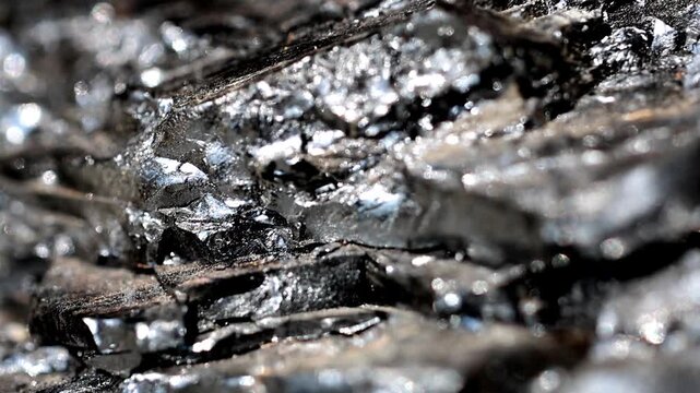 Slow Motion Macro Shot of Anthracite coal showing iridescent sheen, close-up of the metamorphic rock with carbon content and shiny surface at 180 fps High quality footage