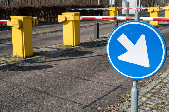 Blue arrow sign directing traffic at parking barrier