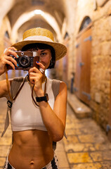 Obraz premium Young girl photographer takes pictures and enjoys the process of shooting. Traveling in Arab countries.