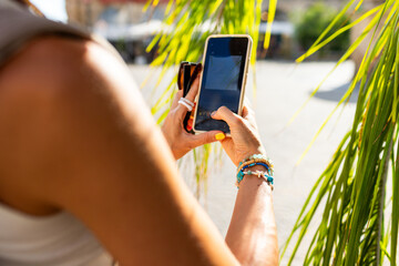girl walks around old city in arab country and takes photos for social networks. girl with phone takes photo of palm tree.
