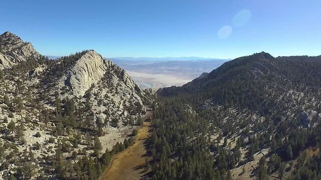 Dramatic flyover of an alpine Sierra Nevada mountain meadow into a rugged and extreme mountain gap that reveals a vast desert valley beyond.  (From Templeton Meadow to Cartego Canyon.)
