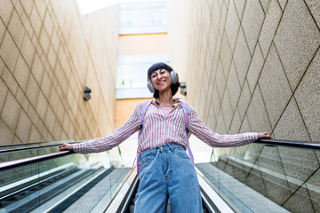 Portrait of a happy woman listening to music on headphones, enjoying her favorite song.