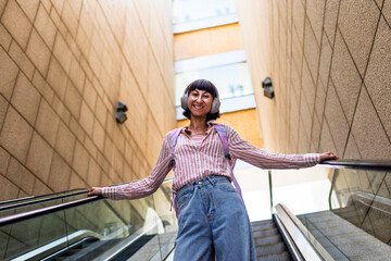 Portrait of a happy woman listening to music on headphones, enjoying her favorite song.