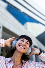 A charming young woman listens to music on headphones. A happy, relaxed girl enjoys her favorite song.