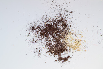Brown and beige eye shadow scattered on white background, texture for makeup