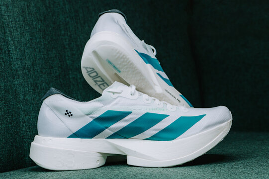 Adidas Adizero Adios Pro 4 Cloud White Pure Teal racing supershoes isolated on white, lightweight carbon road shoes with Lightstrike Pro foam.