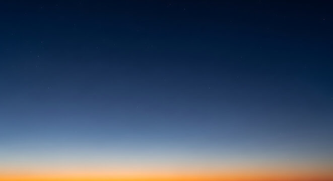 Vast expanse of the night sky transitioning from deep blue to a warm orange horizon