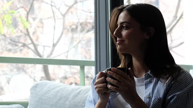 Adult woman relaxing on living room sofa at home, calm and smiling with positive thoughts, single lifestyle moment with mindfulness, wellbeing and mental clarity