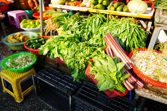 Vegetables market. Vendors display various types of fresh vegetables in baskets for sale in local at market. Fresh green vegetables at vegetable market. Vendors showcasing  produce to customers.