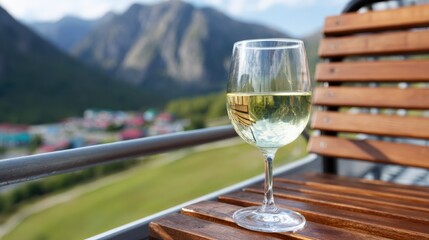 Fototapeta premium Glass of white wine on balcony with scenic mountain view