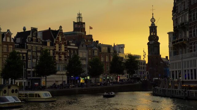 Amsterdam, Netherlands &ndash; September 17, 2024 Amstel River Twilight Cruising near the Munttoren Tower Amsterdam 4K UHD.Boating on the Amstel River at dusk near the Munttoren Tower. Amsterdam, Netherland