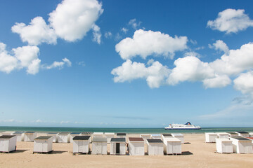  cabines de plage blanches sur la plage de sable de Calais devant la Manche sur la C&ocirc;te d'Opale en &eacute;t&eacute; dans le Pas-de-de-calais, r&eacute;gion hauts de France. Ferry entre la France et l'Angleterre 