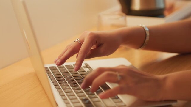 Focused woman editing at hotel. Woman concentrating on computer work at hotel room desk during night hours. Dedicated woman editing document at hotel desk under lamp light during evening hours