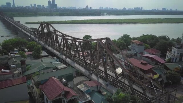 Aerial view of a train crossing the historic long bien bridge over the red river in hanoi