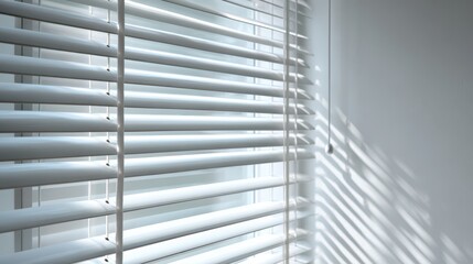 Obraz premium Modern interior with horizontal white blinds and gentle daylight on a plain wall