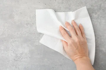 Selbstklebende Fototapeten Altes Krankenhaus Beelitz Woman wiping grey textured surface with paper towel, top view. Space for text  © New Africa