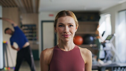 Fototapeta premium Fit lady looking camera in sport club closeup. Smiling woman showing thumb up