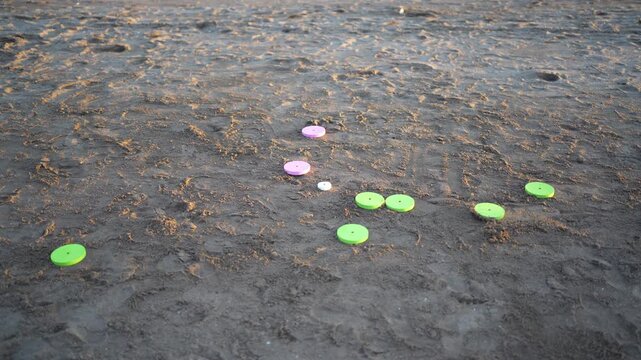 Green tejo disc hitting the sand during a beach game