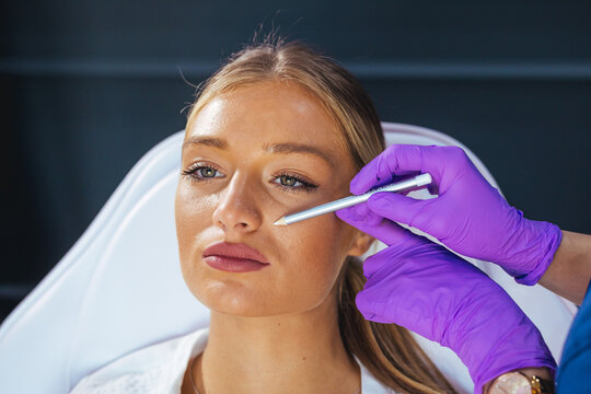 Young Woman Undergoing Facial Cosmetic Marking Consultation With Medical Professional In Aesthetic Clinic