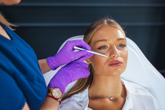 Cosmetic Facial Treatment In Clinic With Professional Wearing Purple Gloves Attending Female Patient