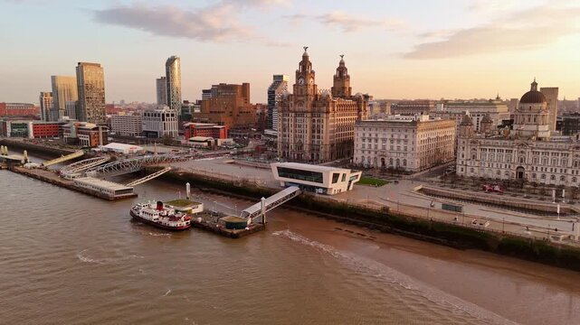 Mersey Ferry Docking at Liverpool Pier Head in front of the Three Graces at sunrise