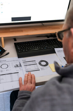 Man Reviewing Budget and Financial Reports at Home Office &ndash; Personal Finance Concept