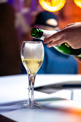 Naklejka premium Pouring in glasses of french sparkling wine champagne with little bubbles, tasting wine, celebration, wedding or champagne tour with visit of caves, Reims, France