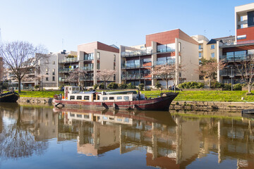 Obraz premium Bâtiments modernes et péniche vus depuis les quais de La Prévalaye sur la rivière Vilaine à Rennes, en Bretagne, France