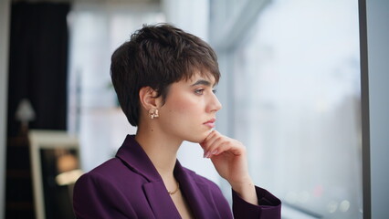 Fototapeta premium Pensive woman director standing window business center looking cityscape closeup