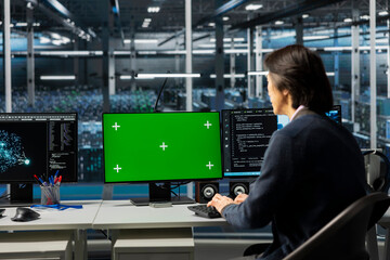 Fototapeta premium IT specialist using isolated screen PC in server room with infrastructure supporting data mining. Worker using mockup computer in data center to do maintenance on mainframes