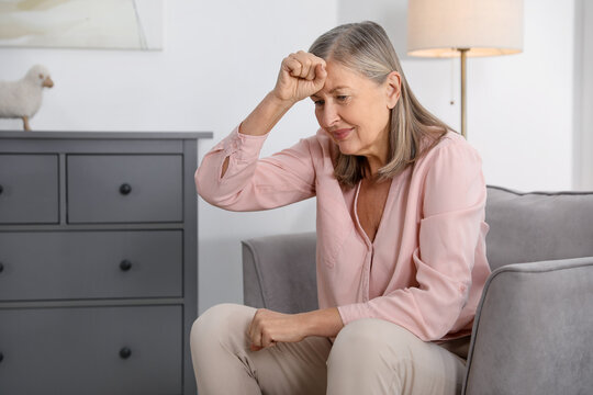 Amnesia. Senior woman trying to remember something at home