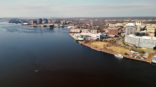 Aerial cinematic view of downtown Norfolk Virginia waterfront featuring Nauticus museum and the USS Wisconsin battleship