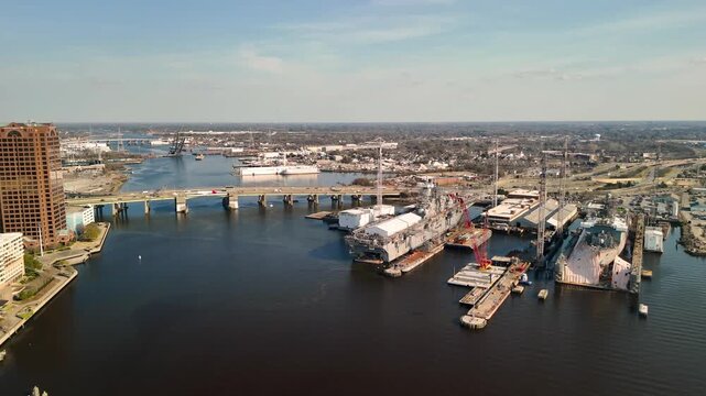 Aerial cinematic view of downtown Norfolk Virginia waterfront featuring Nauticus museum and the USS Wisconsin battleship