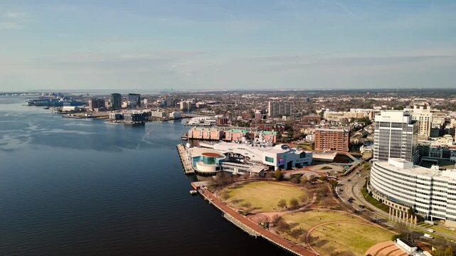 Aerial cinematic view of downtown Norfolk Virginia waterfront featuring Nauticus museum and the USS Wisconsin battleship