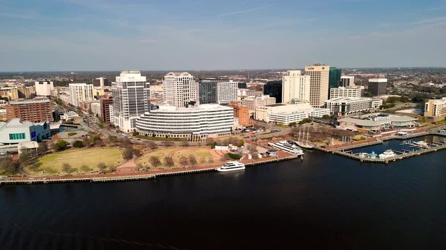 Aerial cinematic view of downtown Norfolk Virginia waterfront featuring Nauticus museum and the USS Wisconsin battleship