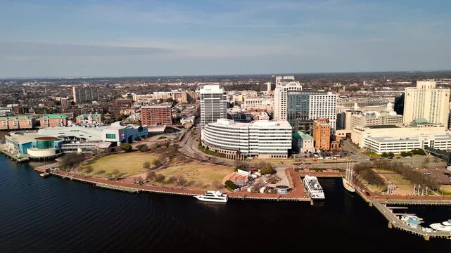 Aerial cinematic view of downtown Norfolk Virginia waterfront featuring Nauticus museum and the USS Wisconsin battleship