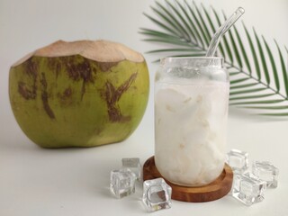 Fresh Coconut Water With Ice In Glass Jar And Whole Green Coconut