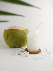 Fresh Coconut Water With Ice In Glass Jar And Whole Green Coconut