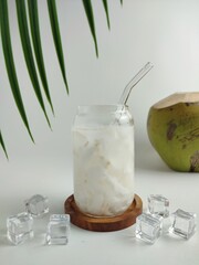 Fresh Coconut Water With Ice In Glass Jar And Whole Green Coconut