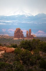 Scenic, dramatic long distance shot of the the La Sal Mountains with Turret arch formations in front at Arches National Park. Tourist landmark, sightseeing in Utah. Vertical banner © piksik