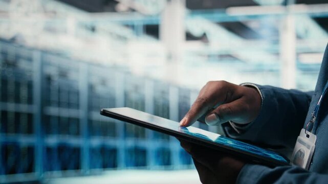Close up of data center engineer using AI software on tablet to optimize performance and forecast issues. Programmer integrating artificial intelligence automation in data center operations, camera A
