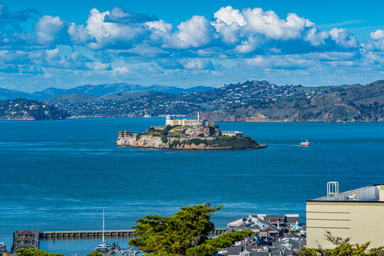 Alcatraz island view with historic site and boats on blue water under a bright sky in a coastal area