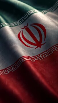 Close-up of the Iranian national flag showing detailed fabric texture and vibrant colors.