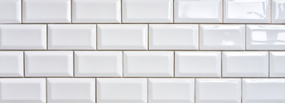Fundo de parede com padr&atilde;o de azulejos retangulares brancos, textura brilhante e tridimensional.