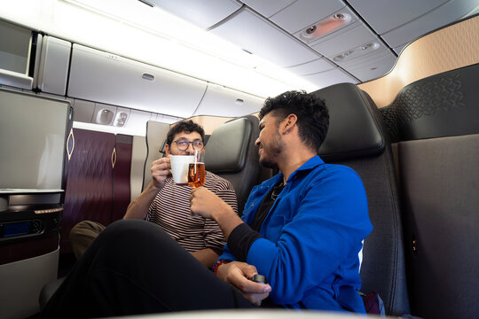 Travelers relaxing in premium airplane seats during flight