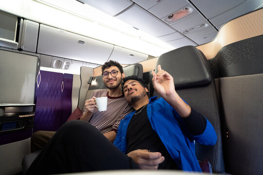 Friends enjoying flight in airplane business class cabin