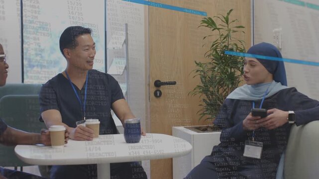 Medical staff chatting on break, right person checking phone, leaning back blue overlay appearing