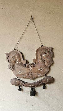 A traditional Indonesian horse dance or kuda lumping from east java ponorogo wall decoration is attached to the yellow wall.