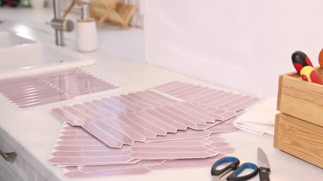 Stylish peel and stick tiles on wall and tools in kitchen