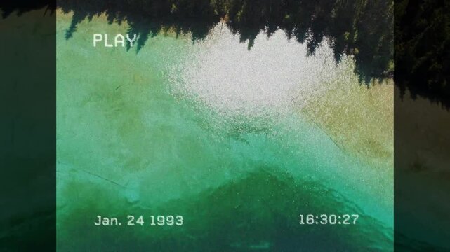 VHS PLAY starting, timestamp ticking, camera pulling up showing green water shifting into canopy
